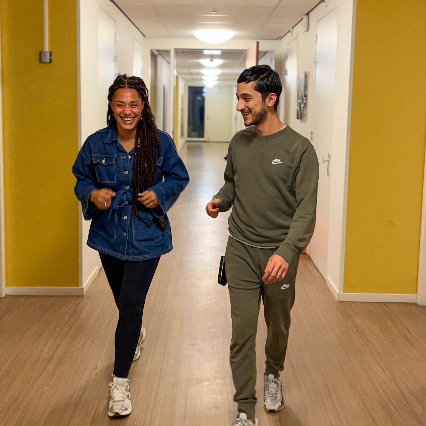 Lativa loopt met een collega door de gang van een woonlocatie